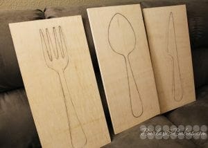 Large plywood pieces with drawings of a fork, spoon and knife image.