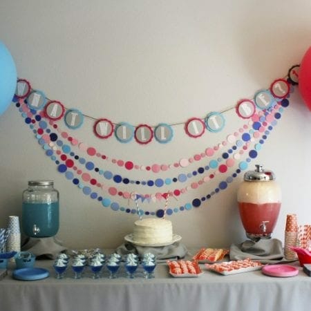 Pink and blue banners, drinks, plates, cups and foods image.