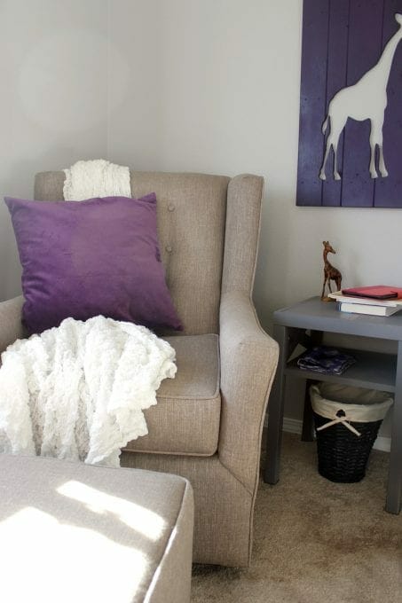 Chair in baby nursery with purple pillow image.