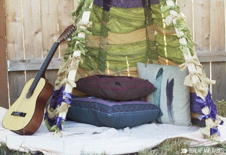 DIY No-Sew Teepee outdoors with pillows, blanket and guitar image.