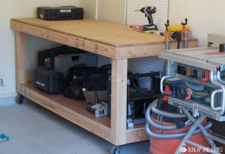 Rolling workbench made from wood sitting in a garage image.