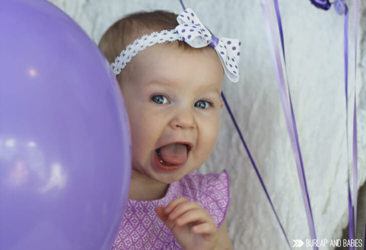 Little girl hiding behind balloon image.
