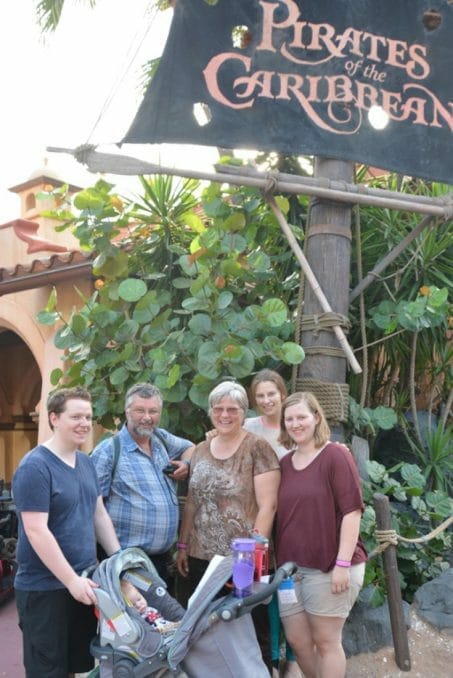 Family posing in front of a Pirate's of the Caribbean sign image.