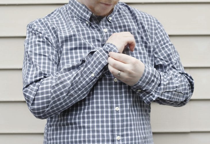 Man buttoning shirt cuff image.