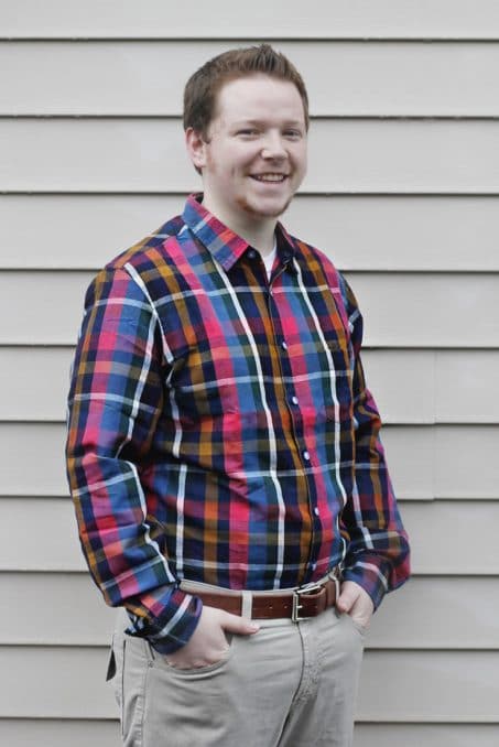 Man smiling in flannel shirt image.