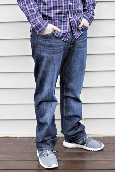 Man with hands in pockets of jeans image.
