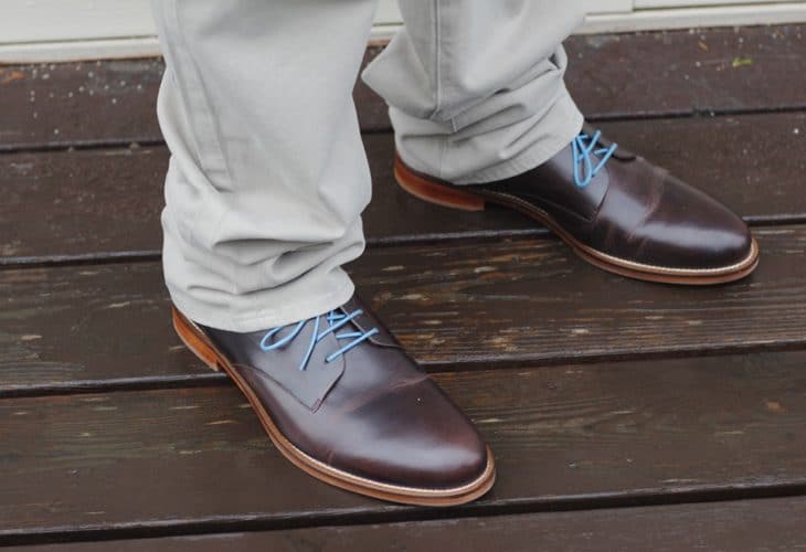 Man's brown shoes with blue laces image.