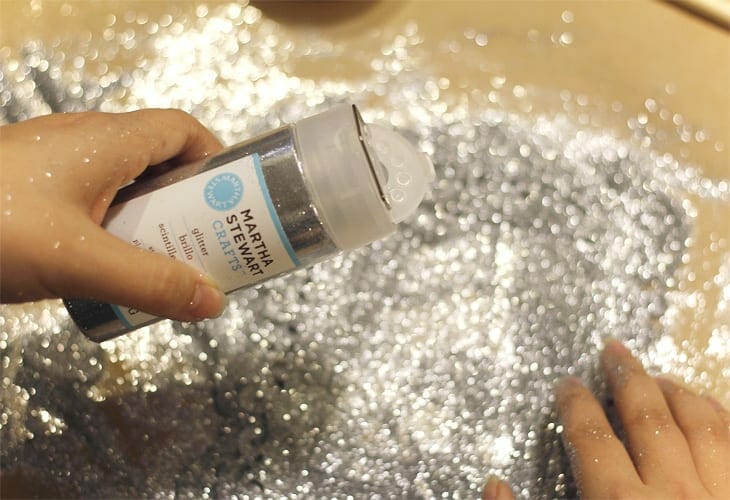 Hands pouring silver glitter image.