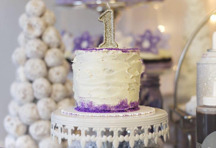 White 1st birthday smash cake with purple trim on cake plate image.