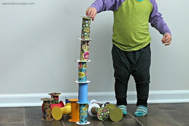 Little boy playing with toilet paper rolls as blocks image.