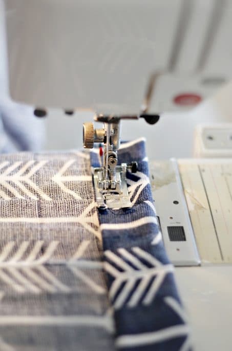 Sewing machine sewing fabric image.