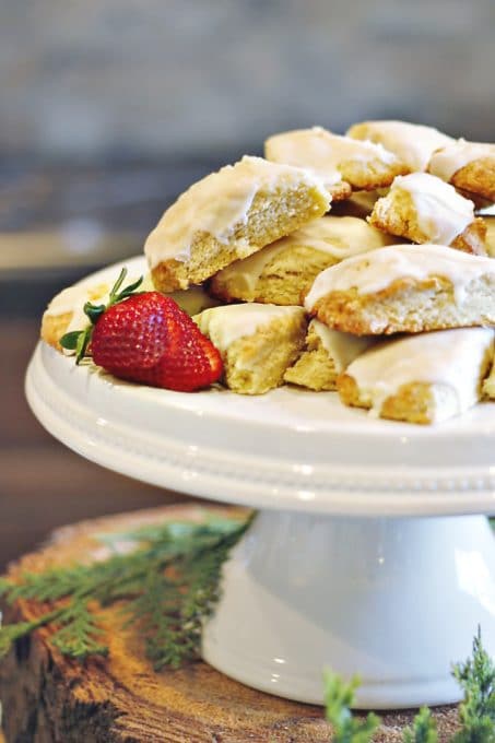 Scones displayed on a white cake stand with a strawberry accent image.