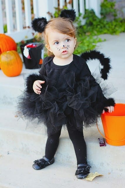 Little girl in DIY black cat costume image.