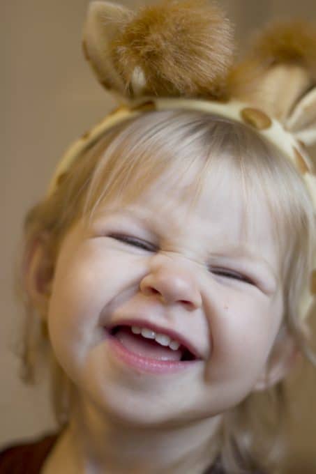 Smiling little girl in a giraffe headband image.