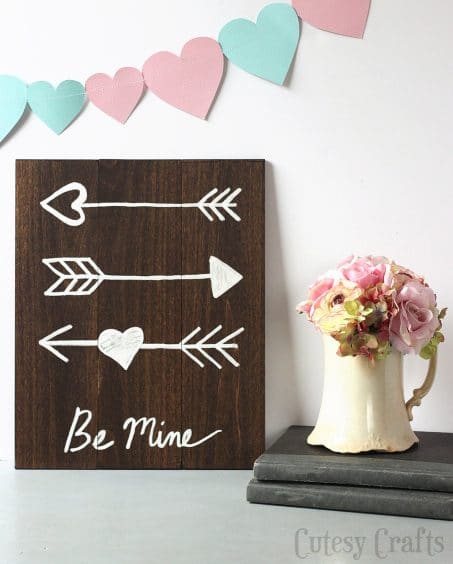 Wooden sign with arrows saying BE MINE image.