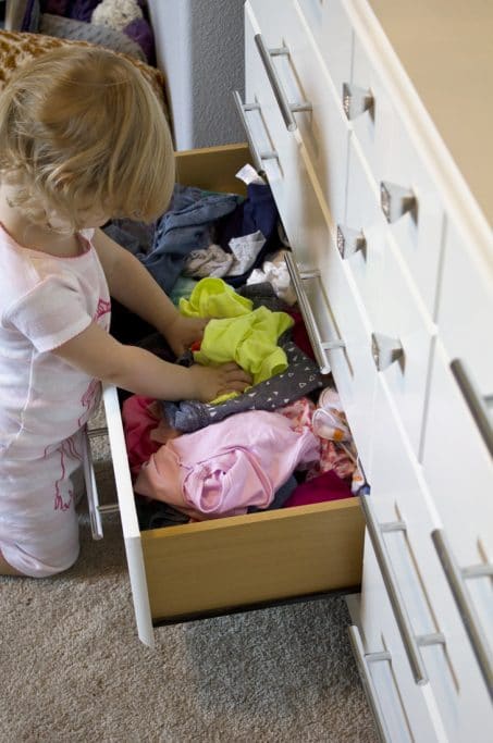 Child getting her clothes our of a drawer image.