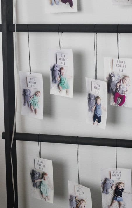 Monthly baby photos hung on a ladder for birthday party