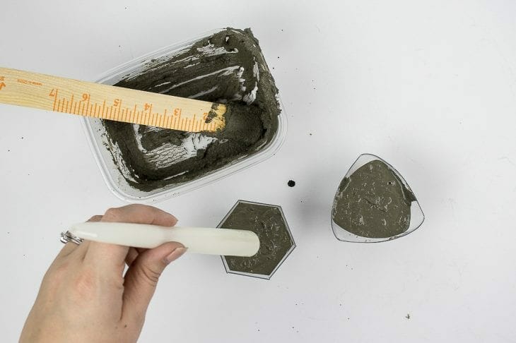 Image of putting candle into cement candle holder
