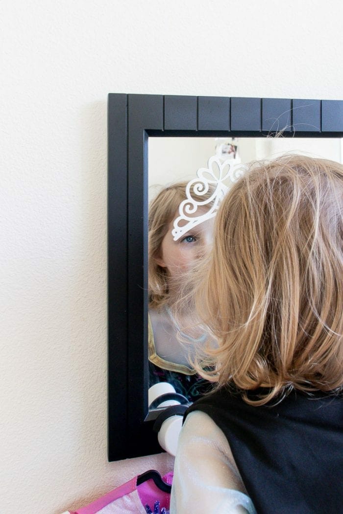 Image of little girl playing dress up looking in mirror