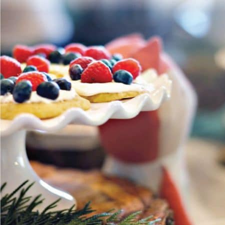 Tarts with berries on a white cake stand image.