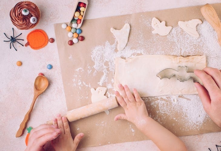 Image of kids rolling dough for Halloween cookies