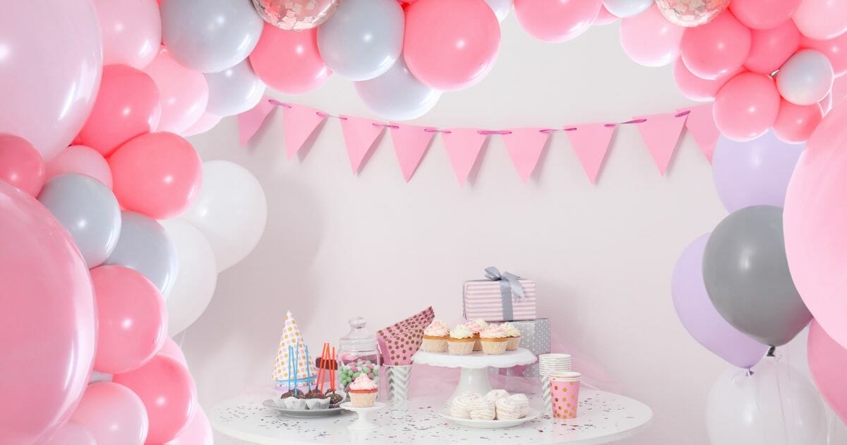 party treats and items on table in room decorated with balloons