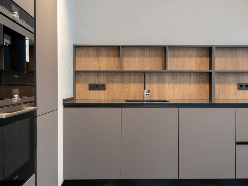 Modern kitchen interior in minimalistic style with grey furniture and built in appliances