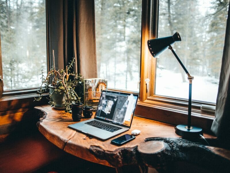 powered-on desk lamp near laptop computer