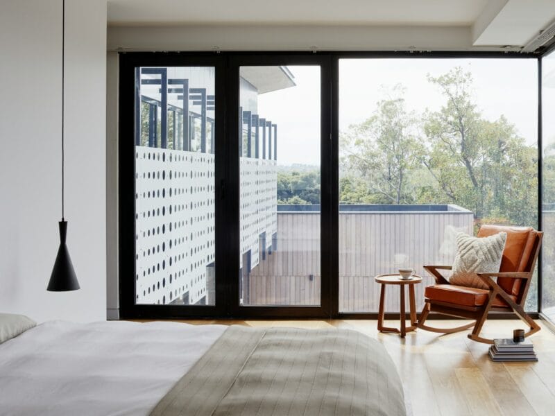 brown wooden armchair near glass window