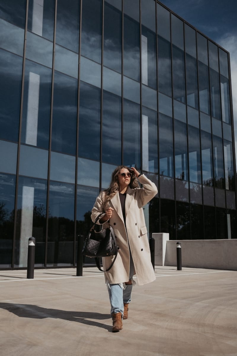 a woman is walking in front of a building