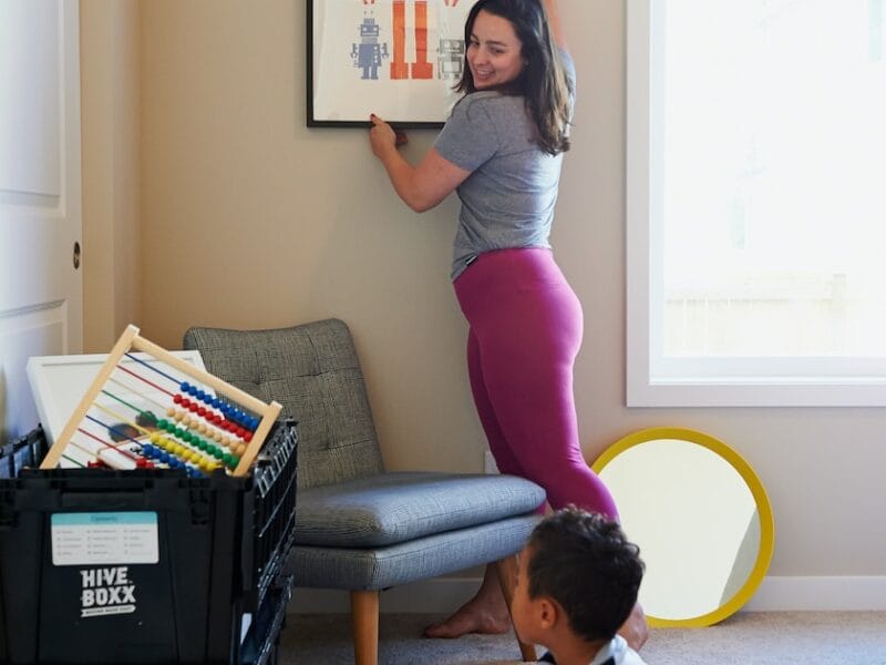 woman in gray shirt and pink pants sitting on gray chair