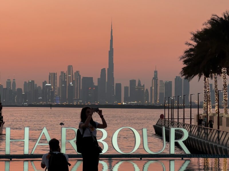 a couple of people standing next to a body of water
