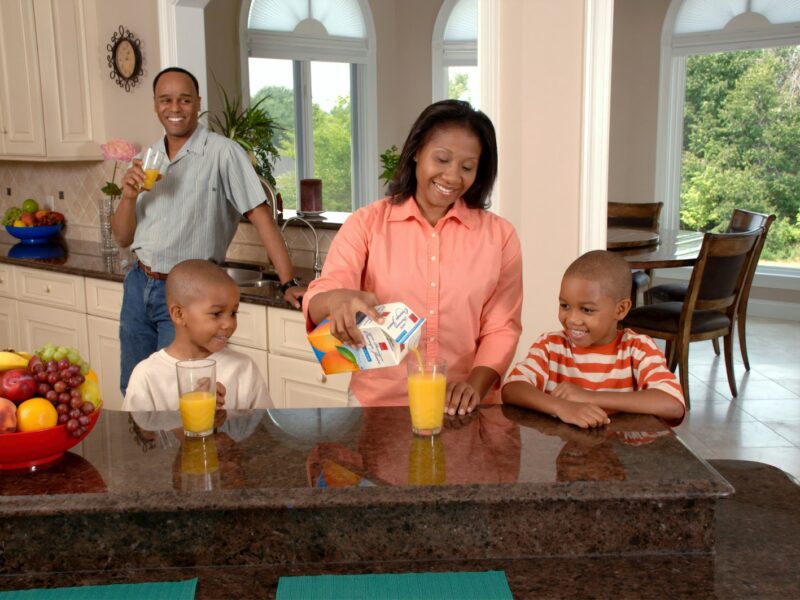 man, woman, and two boys inside kitchen