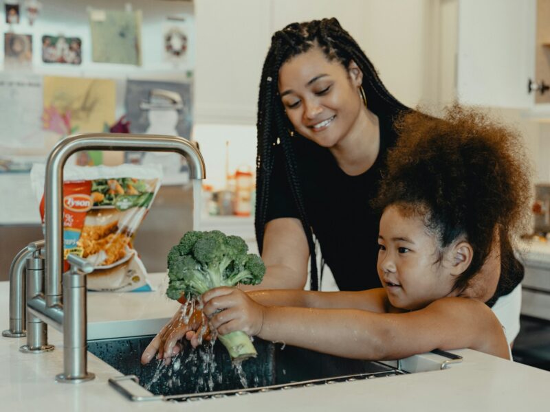 woman in black tank top carrying baby in white tank top