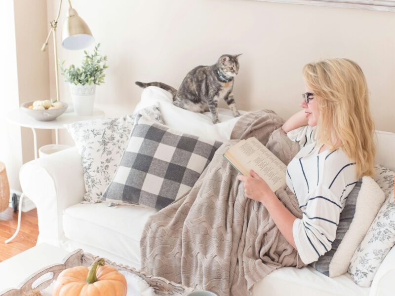 woman reading book on sofa