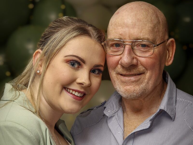 a man and a woman pose for a picture in front of balloons