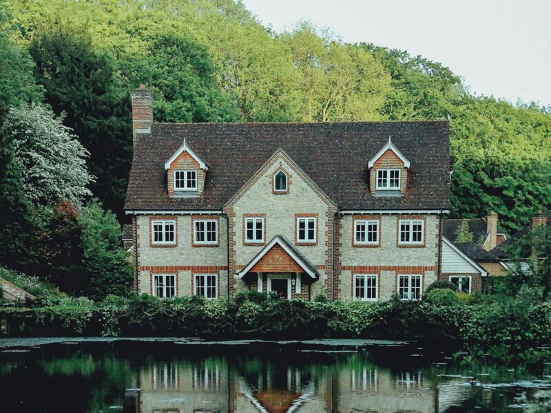 concrete house near a body of water and forest