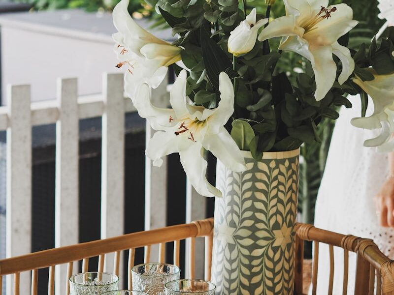 white flowers in white and blue ceramic vase on table