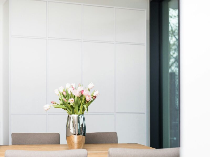 white and pink flowers in clear glass vase on brown wooden table