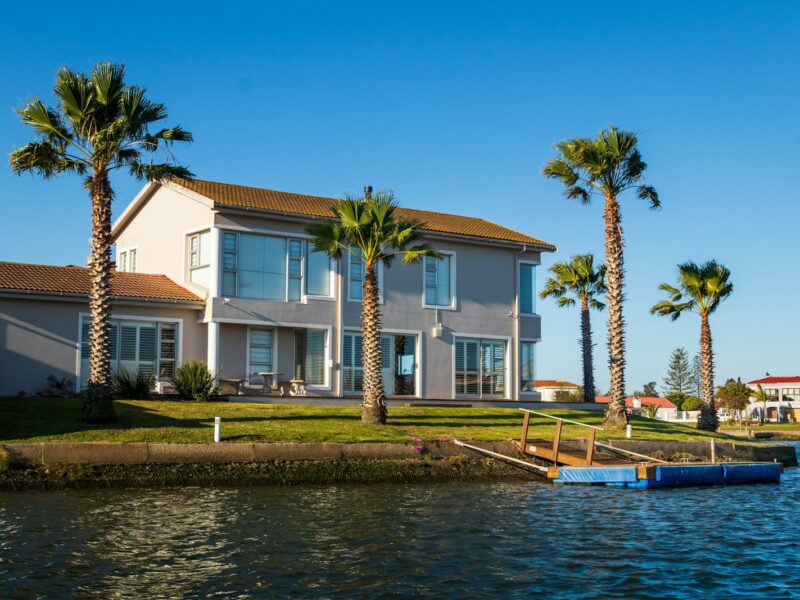 white and brown concrete house beside body of water during daytime