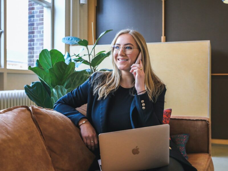woman in blue long sleeve shirt using silver macbook