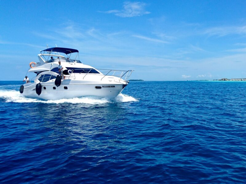 white and blue yacht on sea under blue sky during daytime