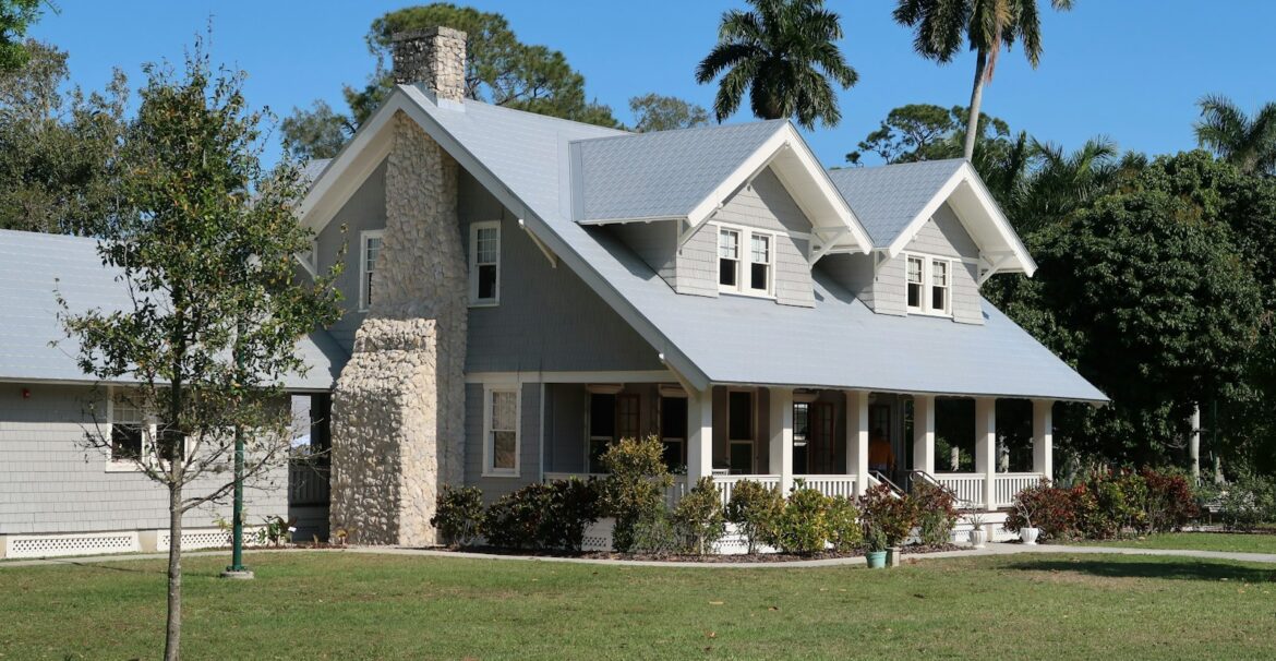 brown and white concrete house near green grass field during daytime