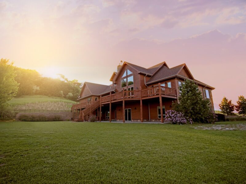 brown wooden house with green grass field