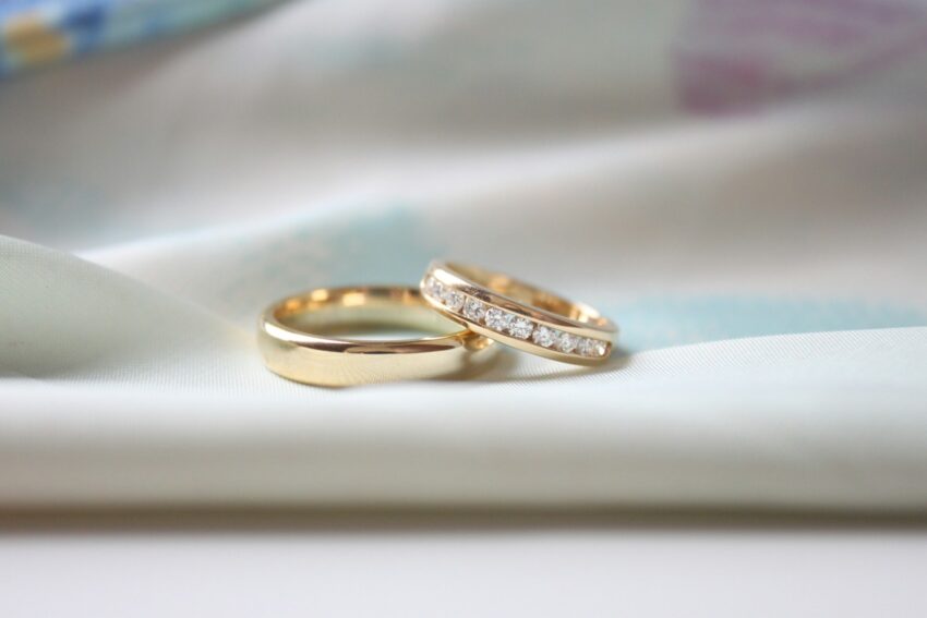 two wedding rings sitting on top of a white cloth