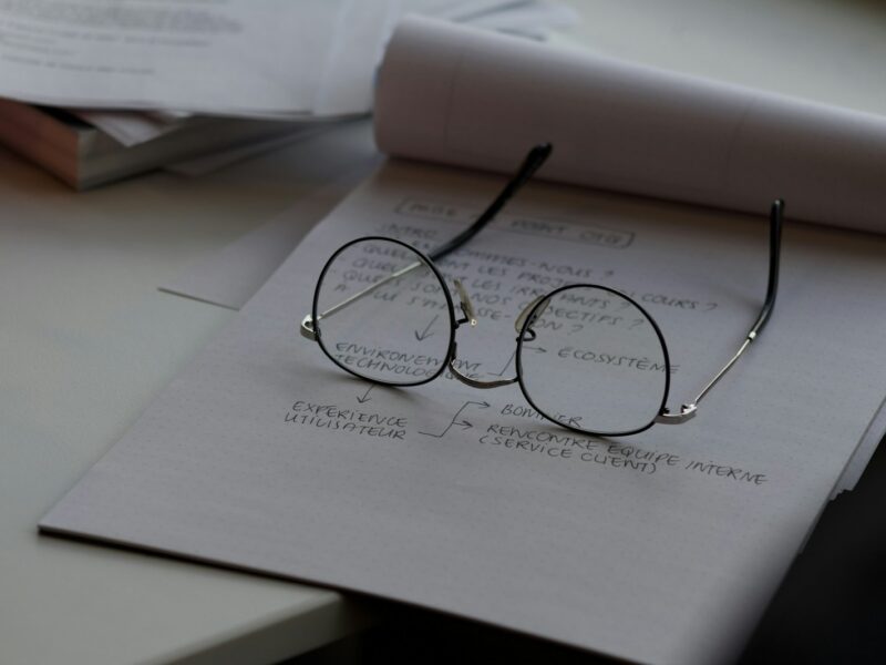 black framed eyeglasses on top of white printing paper