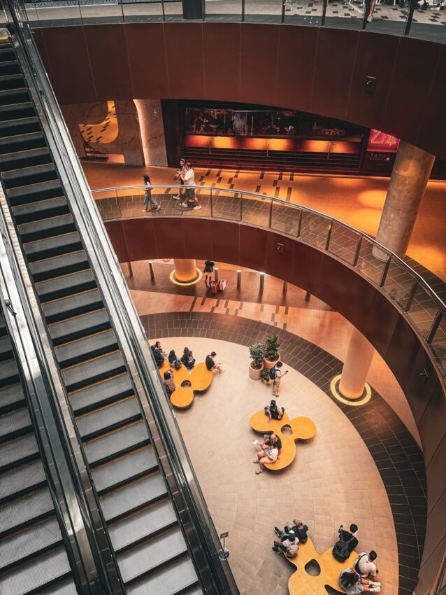 A group of people sitting at tables on top of an escalator