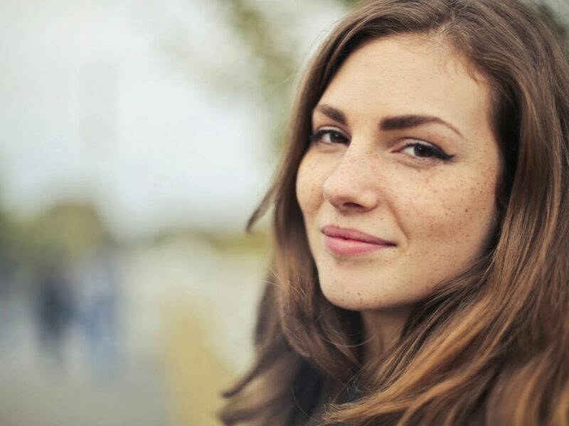 Close-up portrait of a smiling young woman outdoors in Budapest.