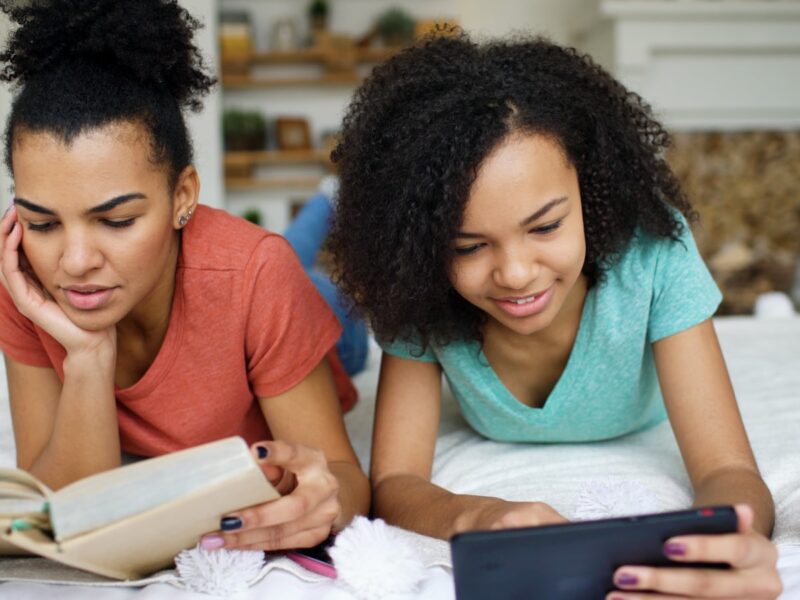 Two young women reading on the floor.