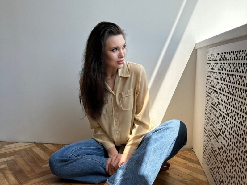 a woman sitting on the floor with her legs crossed